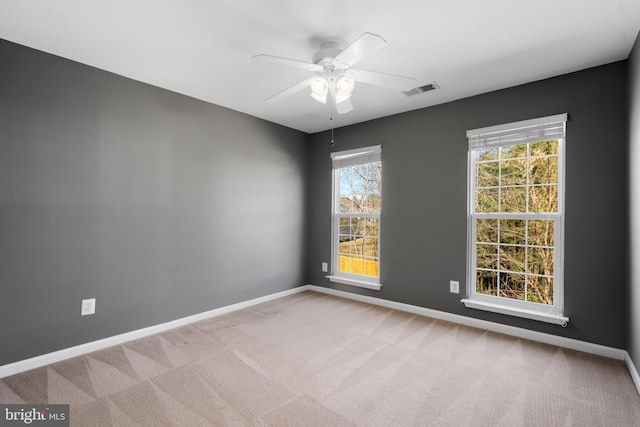 spare room featuring visible vents, ceiling fan, baseboards, and carpet