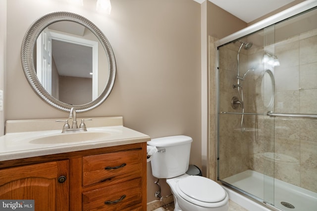 bathroom with vanity, toilet, and a stall shower