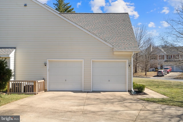 view of home's exterior featuring a garage and roof with shingles