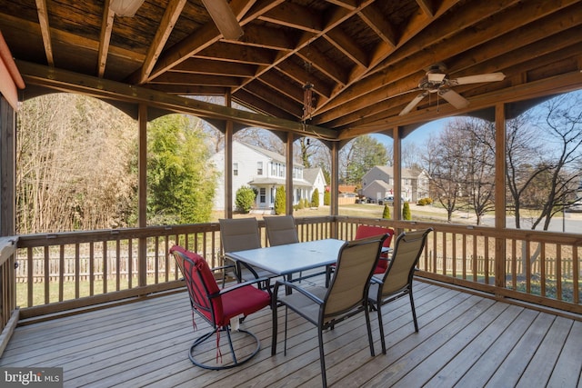 wooden terrace with outdoor dining area, a residential view, and a ceiling fan