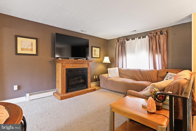 living area with a baseboard heating unit, carpet flooring, a fireplace with raised hearth, and baseboards