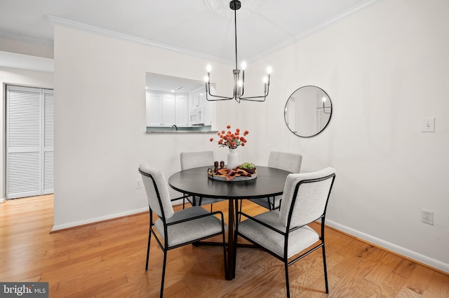 dining room featuring light wood-style floors, baseboards, and crown molding