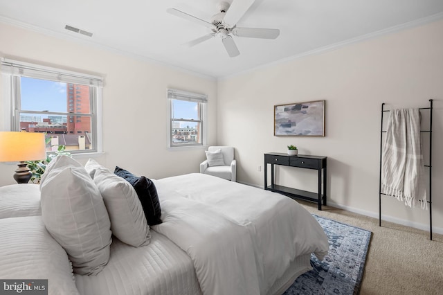 carpeted bedroom featuring visible vents, ornamental molding, ceiling fan, and baseboards