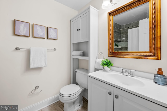 full bathroom with toilet, vanity, and baseboards