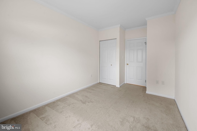 unfurnished bedroom featuring ornamental molding, carpet, a closet, and baseboards