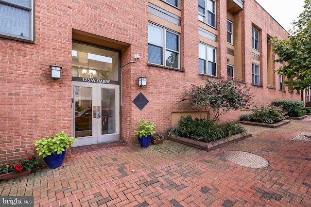 property entrance featuring french doors and brick siding