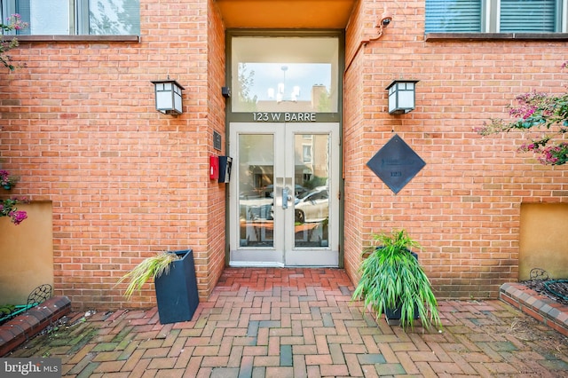 entrance to property featuring brick siding and french doors