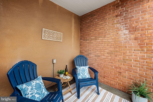 sitting room featuring brick wall