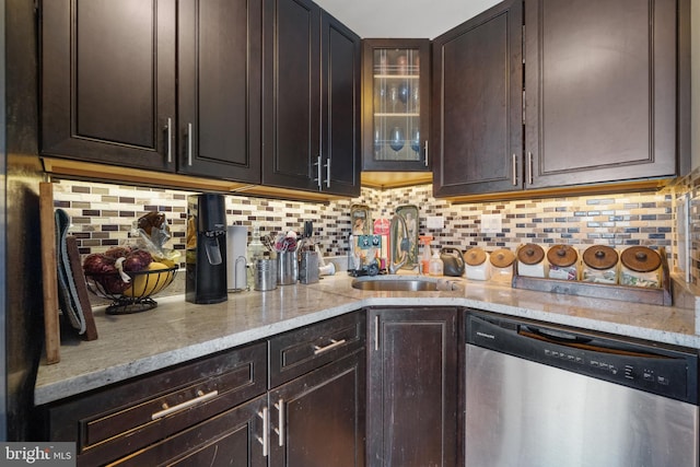 kitchen featuring a sink, light stone counters, stainless steel dishwasher, decorative backsplash, and dark brown cabinets