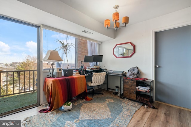 office featuring a notable chandelier, visible vents, and wood finished floors