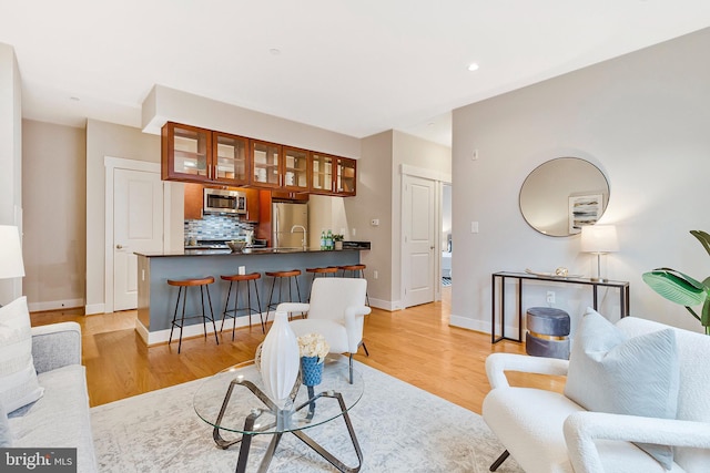 living area featuring light wood-style floors, baseboards, and recessed lighting