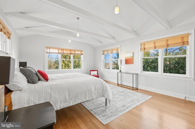 bedroom with lofted ceiling with beams, baseboards, and wood finished floors