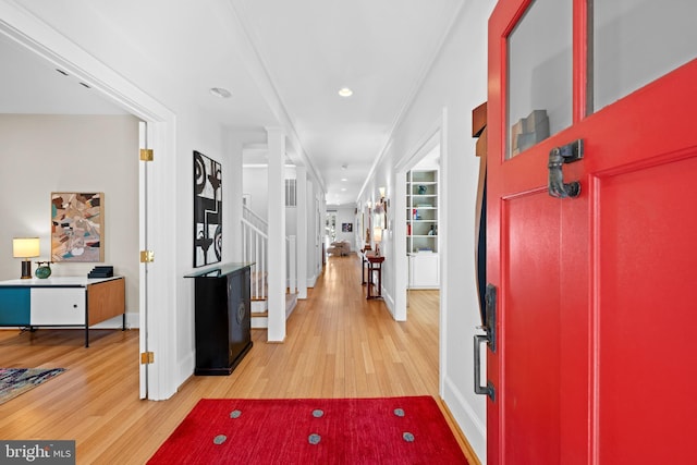 foyer entrance with crown molding, recessed lighting, light wood-type flooring, baseboards, and stairs