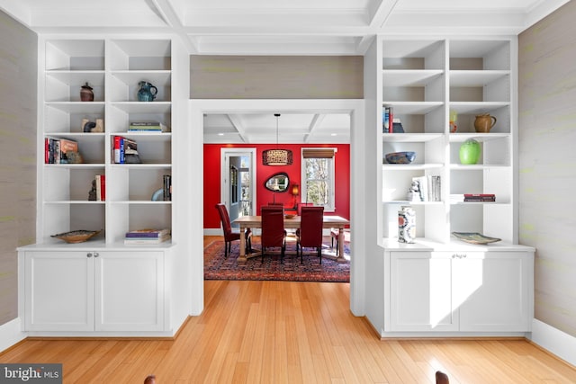 interior space with built in shelves, coffered ceiling, beam ceiling, and light wood-style flooring