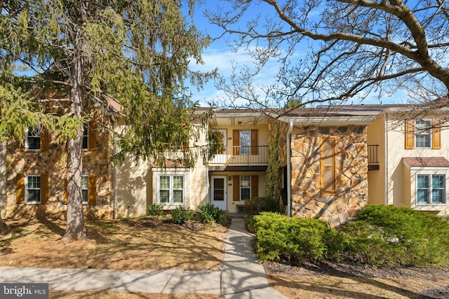 view of front facade featuring a balcony and stucco siding