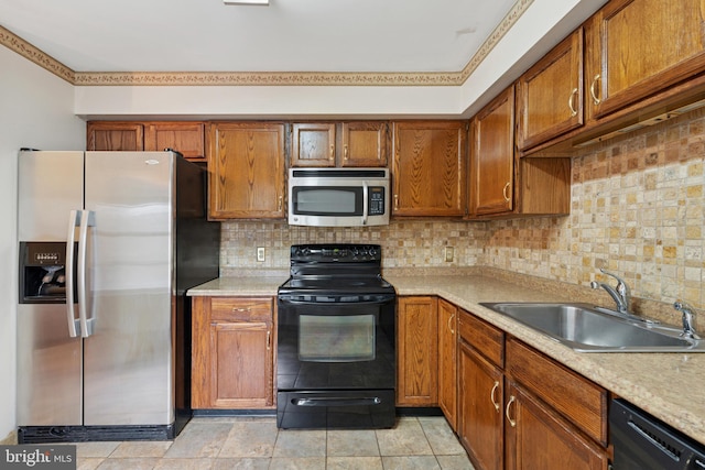 kitchen with black appliances, decorative backsplash, a sink, and light countertops