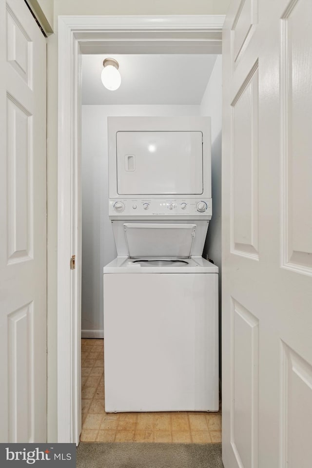 washroom featuring stacked washer / drying machine and laundry area