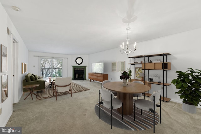 dining room featuring light carpet, a fireplace, and a notable chandelier