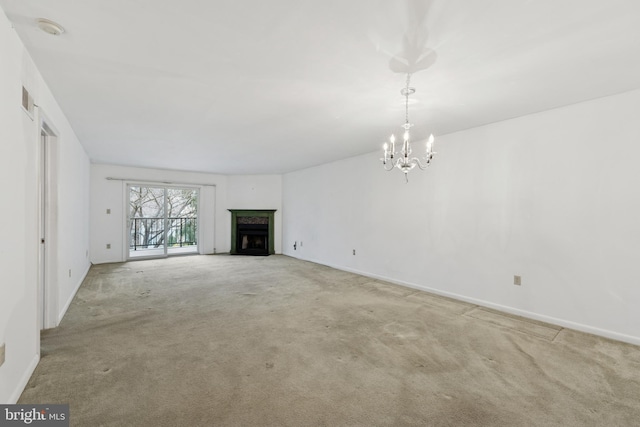 unfurnished living room with carpet floors, a chandelier, baseboards, and a premium fireplace