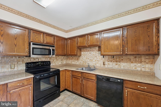 kitchen featuring black appliances, a sink, and light countertops