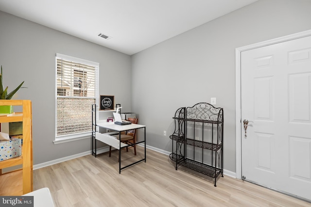 office area featuring light wood-style flooring, visible vents, and baseboards