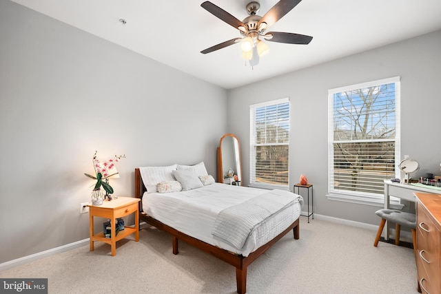 bedroom featuring baseboards, a ceiling fan, and light colored carpet