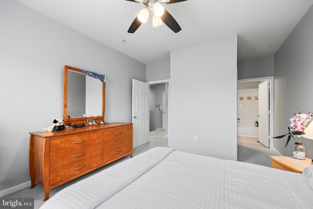 bedroom featuring light carpet, ceiling fan, ensuite bath, and baseboards