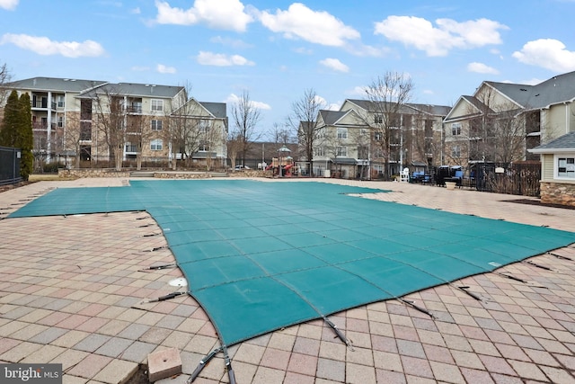 pool featuring a patio, fence, and a residential view