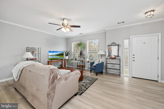 living room featuring baseboards, crown molding, a ceiling fan, and light wood-style floors