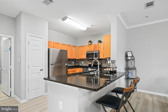 kitchen featuring a peninsula, visible vents, appliances with stainless steel finishes, and a sink