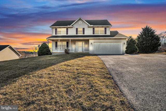 traditional-style house with aphalt driveway, covered porch, an attached garage, and a front lawn