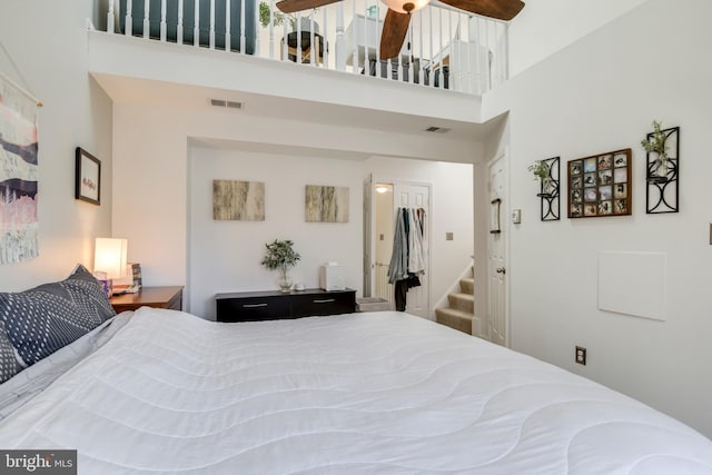 bedroom with a towering ceiling and visible vents