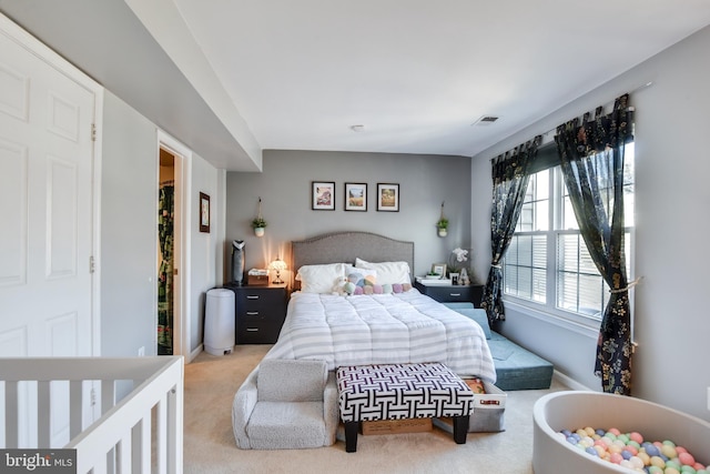 bedroom with light colored carpet, visible vents, and baseboards