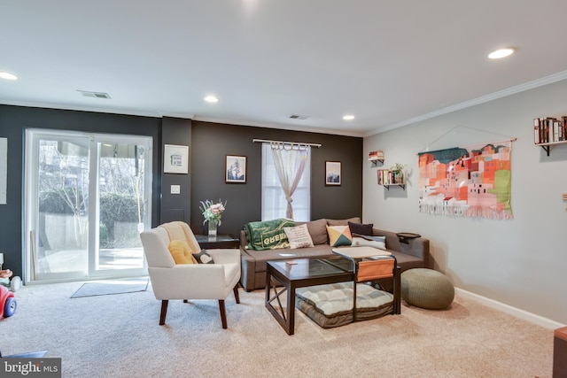 living area with ornamental molding, a healthy amount of sunlight, visible vents, and carpet flooring