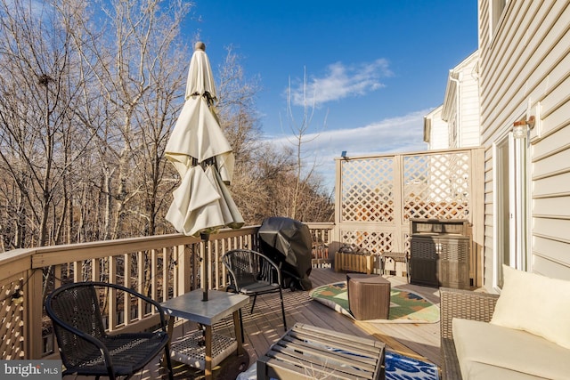 wooden terrace featuring a grill and an outdoor living space