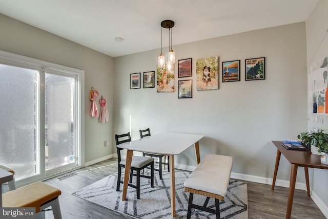 dining area featuring a healthy amount of sunlight, visible vents, and wood finished floors