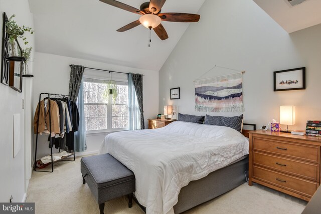 bedroom with high vaulted ceiling, light colored carpet, and a ceiling fan