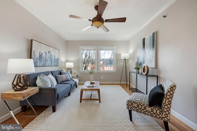 living area with crown molding, baseboards, and wood finished floors