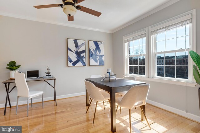 dining area with baseboards, light wood-style floors, ornamental molding, and a ceiling fan