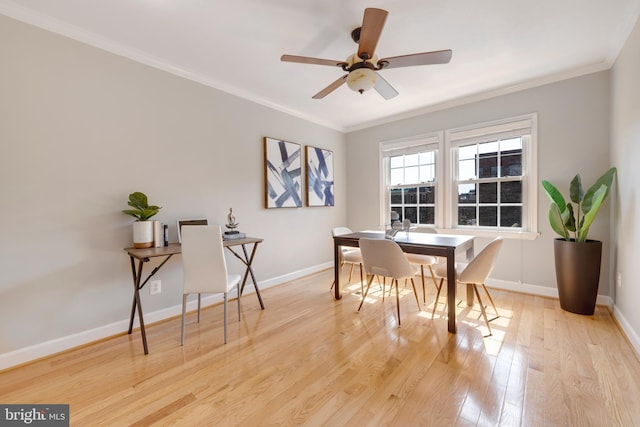 dining room with light wood finished floors, a ceiling fan, crown molding, and baseboards