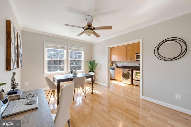 dining area with crown molding, baseboards, light wood-style flooring, washer / clothes dryer, and a ceiling fan