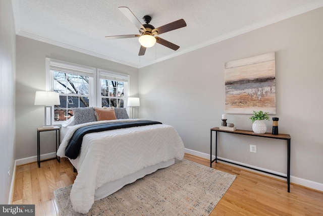 bedroom with crown molding, wood finished floors, and baseboards