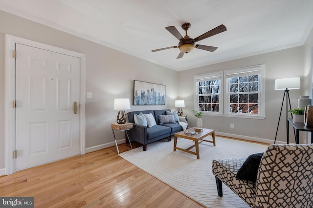 living room featuring baseboards, a ceiling fan, wood finished floors, and crown molding