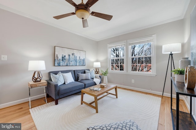 living room with ceiling fan, crown molding, baseboards, and wood finished floors