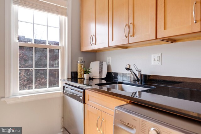 kitchen featuring plenty of natural light, dishwasher, washer / clothes dryer, and a sink