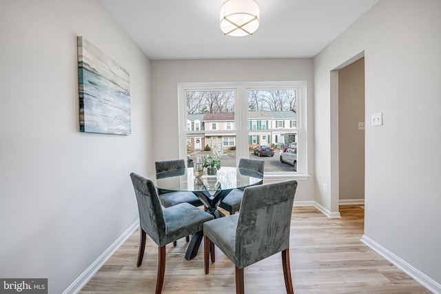 dining room featuring baseboards and light wood-type flooring