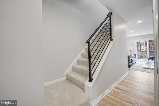 stairway with recessed lighting, wood finished floors, and baseboards