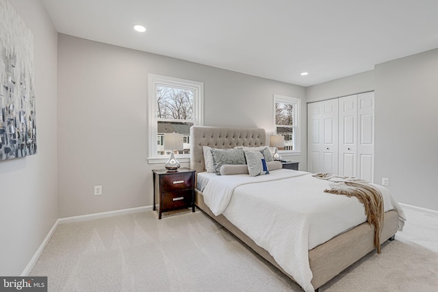 bedroom featuring baseboards, multiple windows, and light carpet