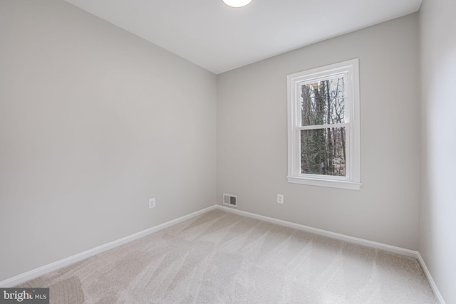 carpeted spare room featuring visible vents and baseboards