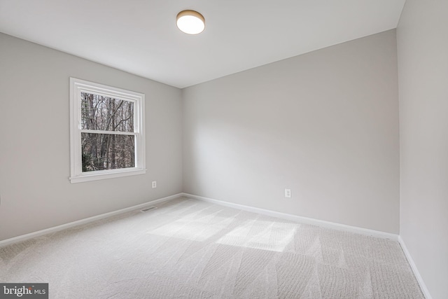 carpeted empty room featuring visible vents and baseboards